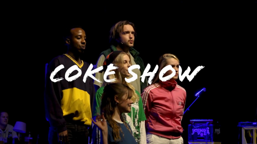 Groep acteurs op podium van de Coke Show